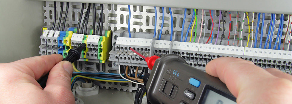 Elektrofachkraft prüft eine elektrische Anlage mit einem Messgerät